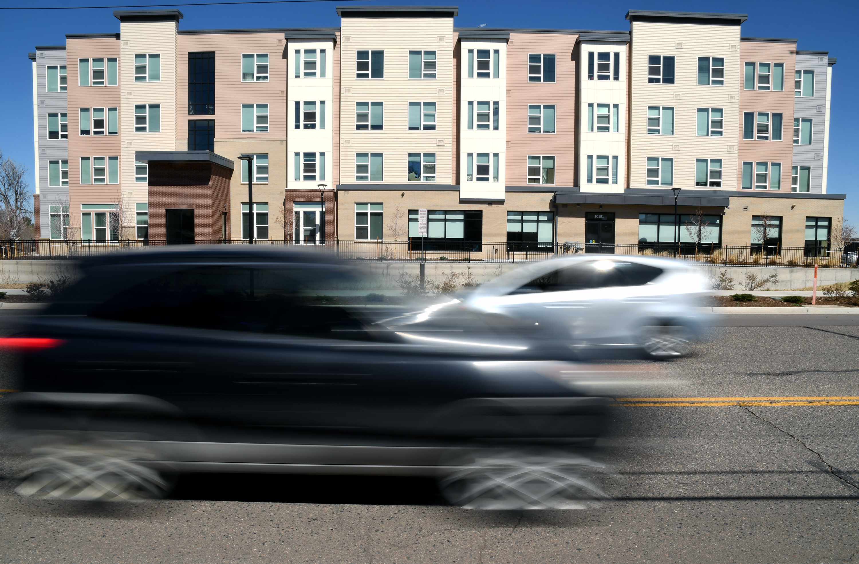 Vehicles pass by the Sapling Grove Apartments, an affordable housing complex, in Aurora, Colo., March 20, 2026.