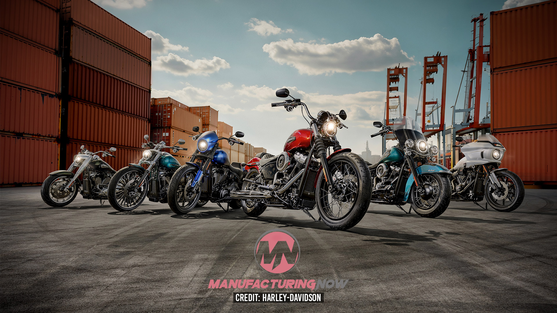 Row of custom motorcycles lined up in a shipping container port yard under blue sky