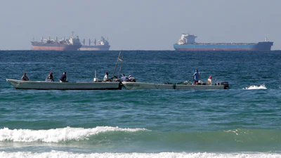 Fishermen work in front of oil tankers south of the Strait of Hormuz Jan. 19, 2012, offshore the town of Ras Al Khaimah in United Arab Emirates.