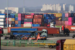 Trucks run by containers at the Uiwang ICD Terminal in Uiwang, South Korea, Thursday, March 12, 2026.
