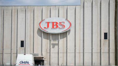 Employees walk in front of the entrance to the JBS meat processing plant, July 23, 2021, in Greeley, Colo.