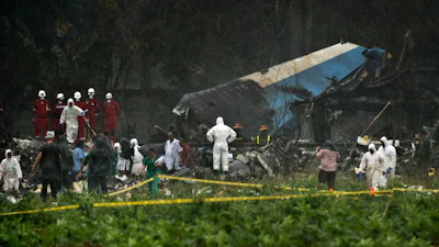 Rescue teams search through the wreckage site of a Boeing 737 that plummeted into a cassava field with more than 100 passengers on board, in Havana, Cuba, May 18, 2018.