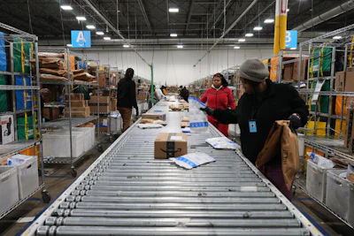 Amazon employees sort packages at a last-mile delivery center in Seaford, Del., Wednesday, Jan. 21, 2026.