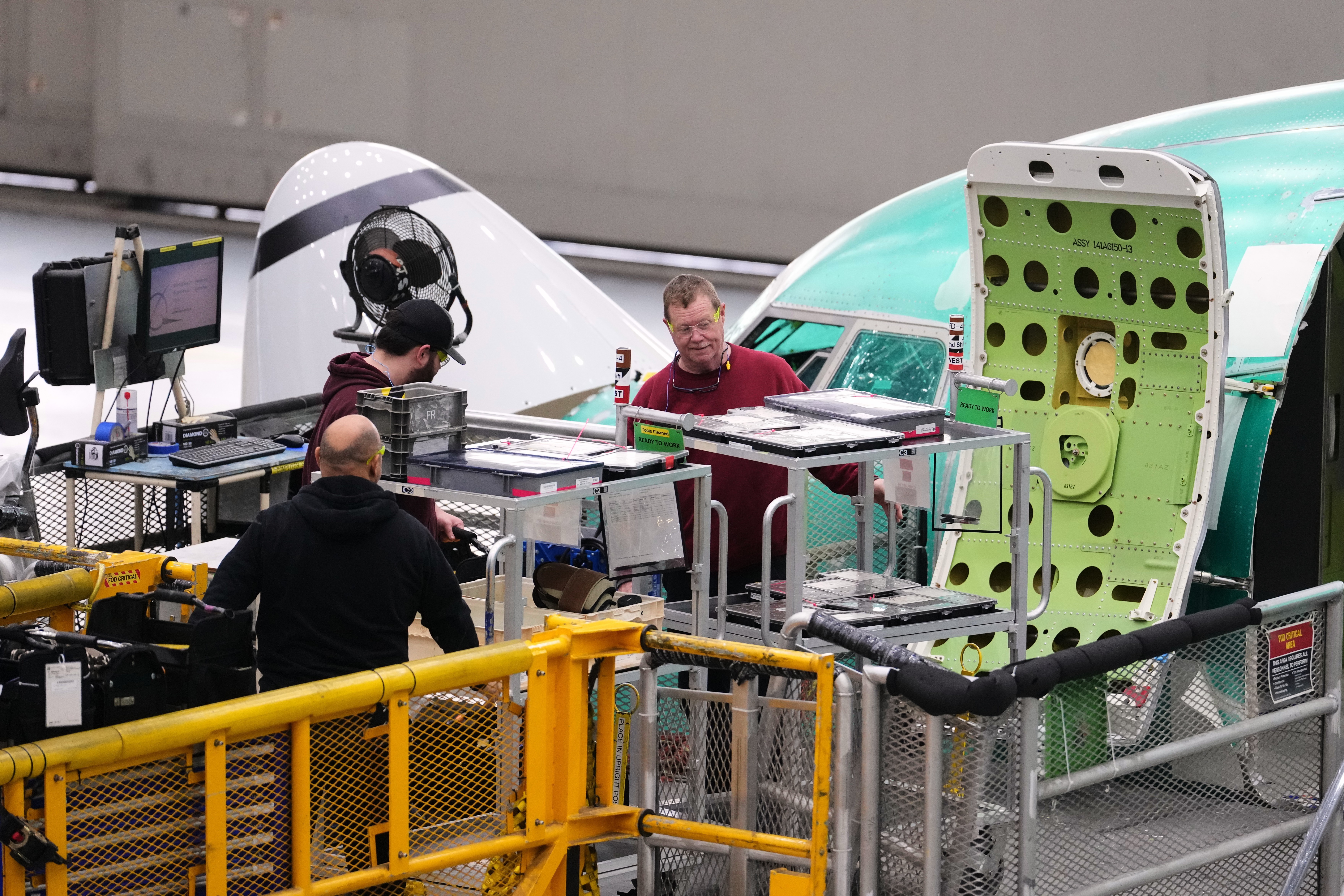 Employees work near the nose of a Boeing 737 MAX airplane on the final assembly line during a media tour at Boeing's factory Wednesday, April 15, 2026, in Renton, Wash.