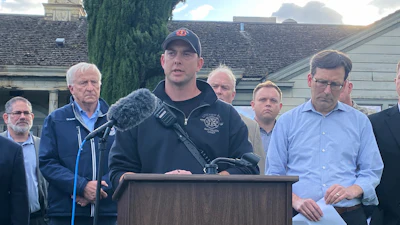 Longview Fire Department Battalion Chief Matt Amos speaks at a press conference in Longview, Wash., Tuesday, May 26, 2026, at the site of a paper mill where a chemical tank failure killed at least one person and left others unaccounted for.