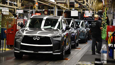 A worker walks past a line of Infiniti SUVs on a production line at the Nissan Smyrna Vehicle Assembly Plant, Thursday, April 16, 2026, in Smyrna, Tenn.