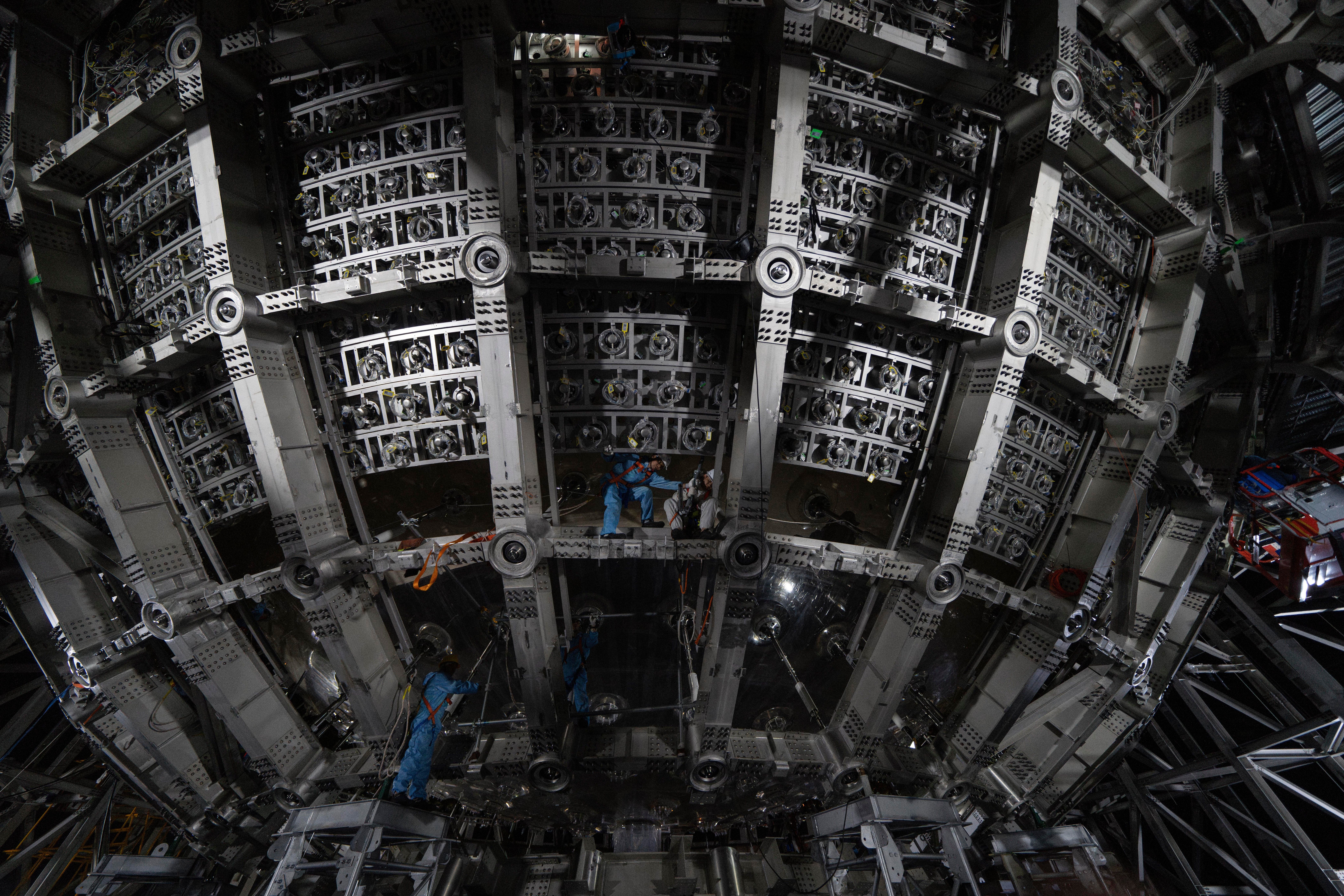Workers labor on the underside of the cosmic detector housed underground at the Jiangmen Underground Neutrino Observatory in Kaiping in southern China's Guangdong province, Oct. 11, 2024.