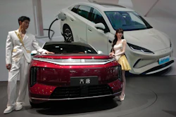 Models stand next to a latest EV car from Chinese automaker BYD showcased at the Auto China 2026, in Beijing, April 25, 2026.