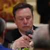 Elon Musk uses his phone during a state dinner for President Donald Trump and Chinese President Xi Jinping at the Great Hall of the People on Thursday May 14, 2026, in Beijing.