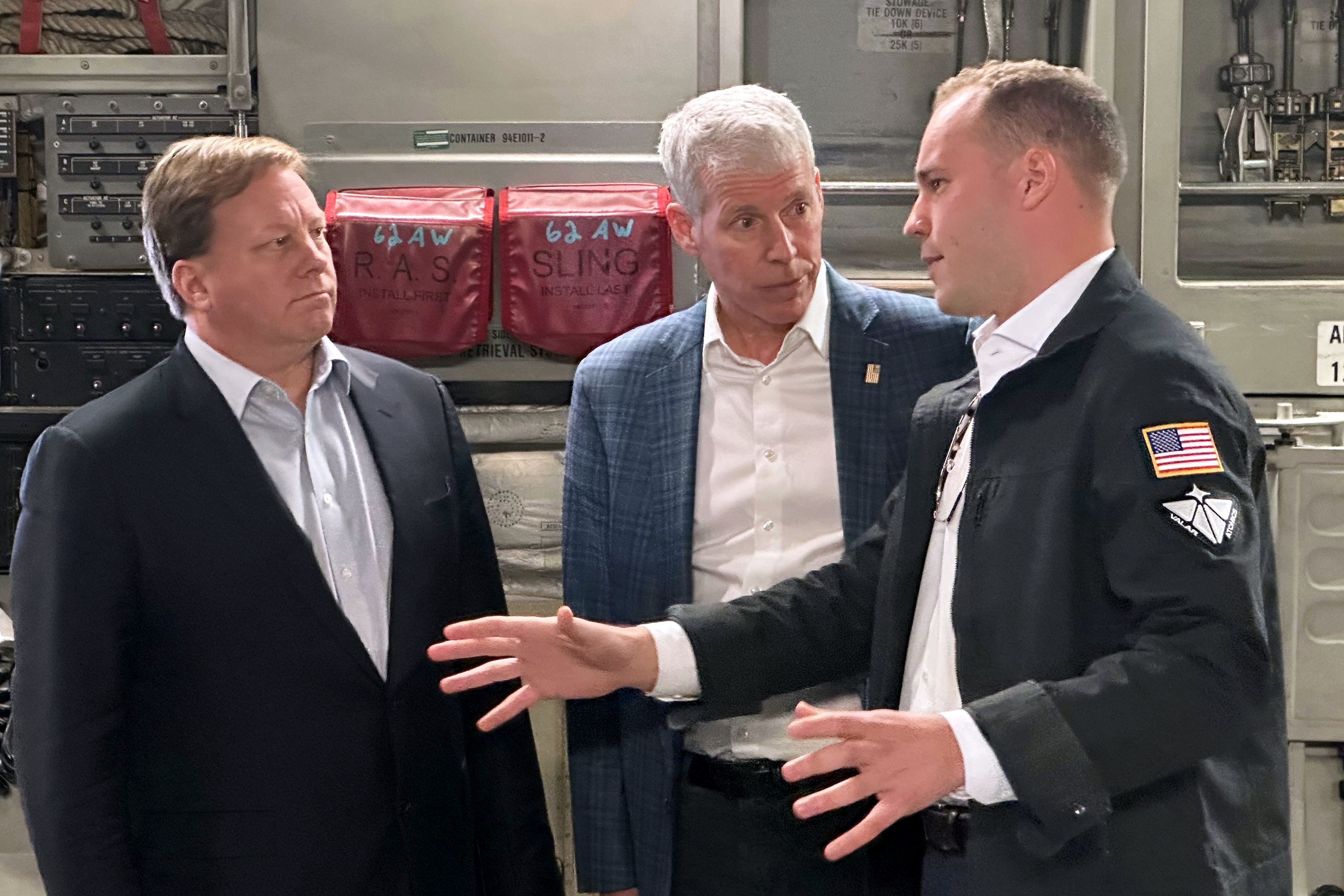 Energy Secretary Chris Wright, center, and Under Secretary of Defense Michael Duffey, left, listen as Isaiah Taylor, CEO of Valar Atomics, discusses a microreactor developed by Valar to generate nuclear power for the military and commercial customers, Feb. 15, 2026, in-flight, on board a C-17.