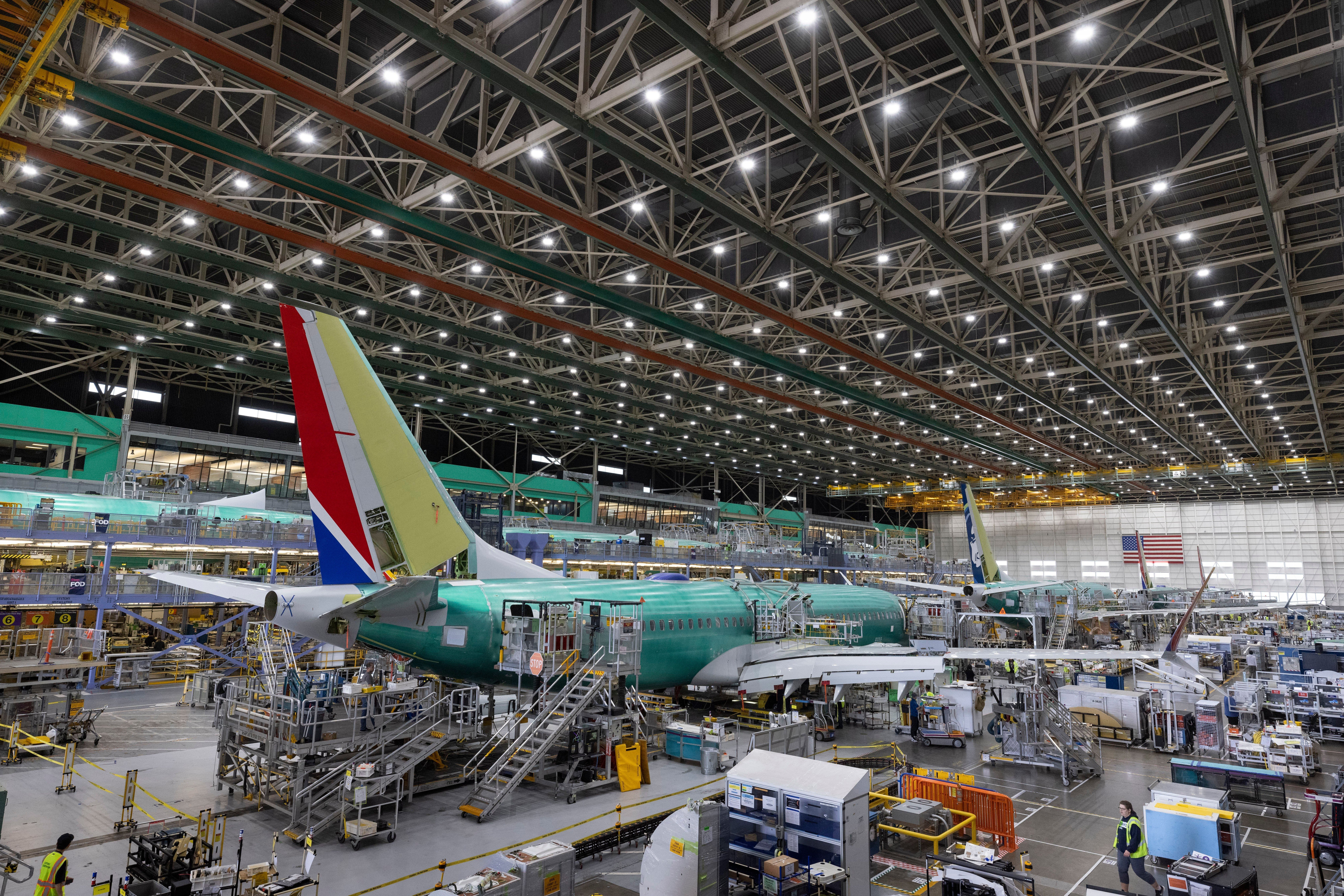 Boeing employees work on a 737 MAX airplane on the final assembly line at Boeing's plant in Renton, Wash., on June 15, 2022.