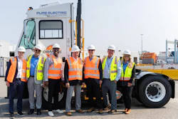 Orange EV and APM Terminals team members gather alongside an Orange EV electric terminal truck.