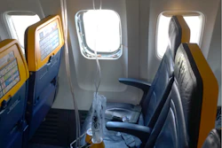 This undated photo provided by the National Transportation Safety Board on Thursday, Aug. 13, 2026, shows the shattered window on a Ryanair plane that was broken by a stray engine part shortly after takeoff, causing a man's head to be sucked into the hole.