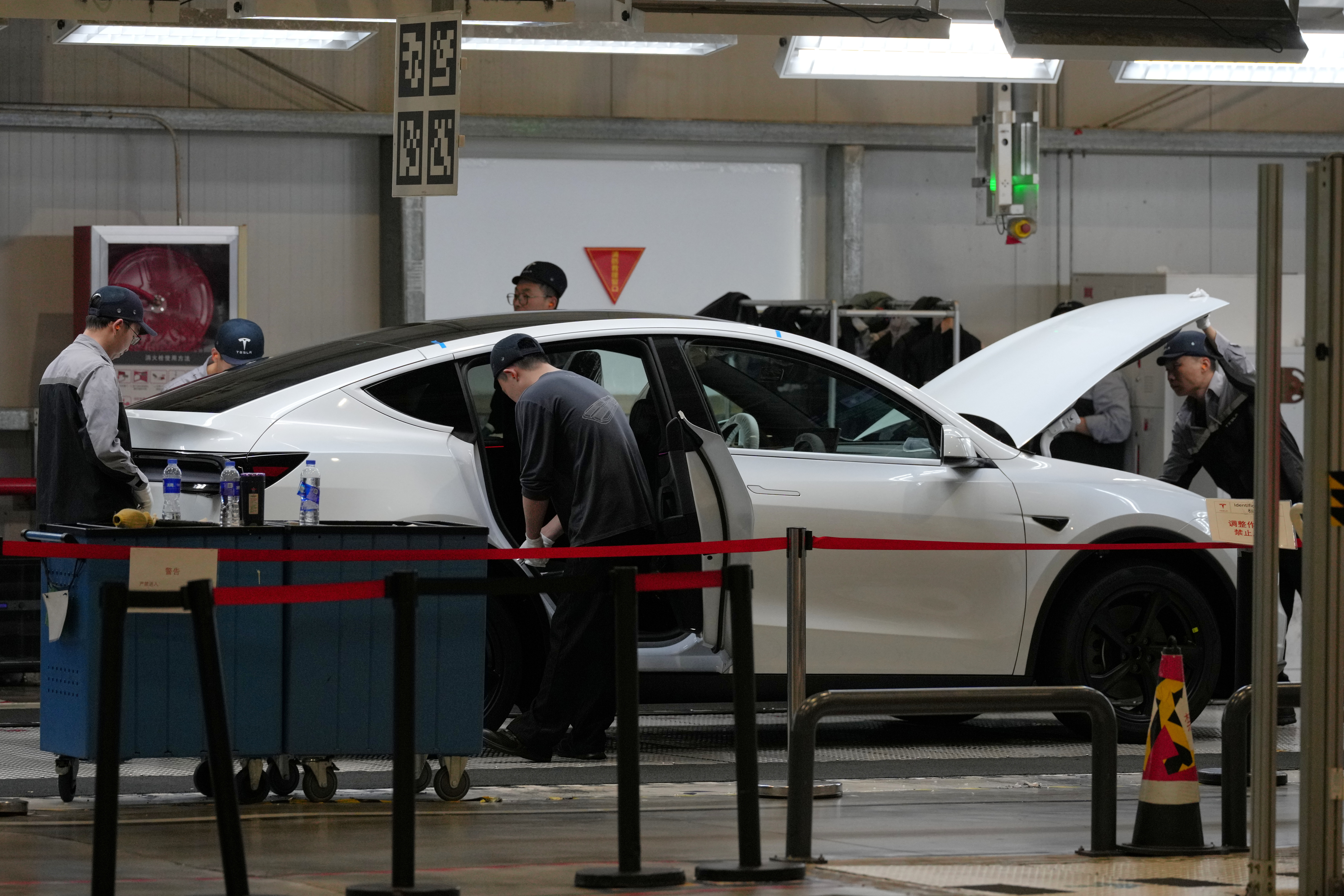 People work on the Tesla Model Y production line at the Tesla Gigafactory assembly plant during a media organized tour, in Shanghai, China, Tuesday, April 14, 2026.