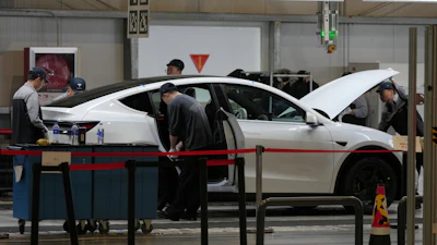 People work on the Tesla Model Y production line at the Tesla Gigafactory assembly plant during a media organized tour, in Shanghai, China, Tuesday, April 14, 2026.