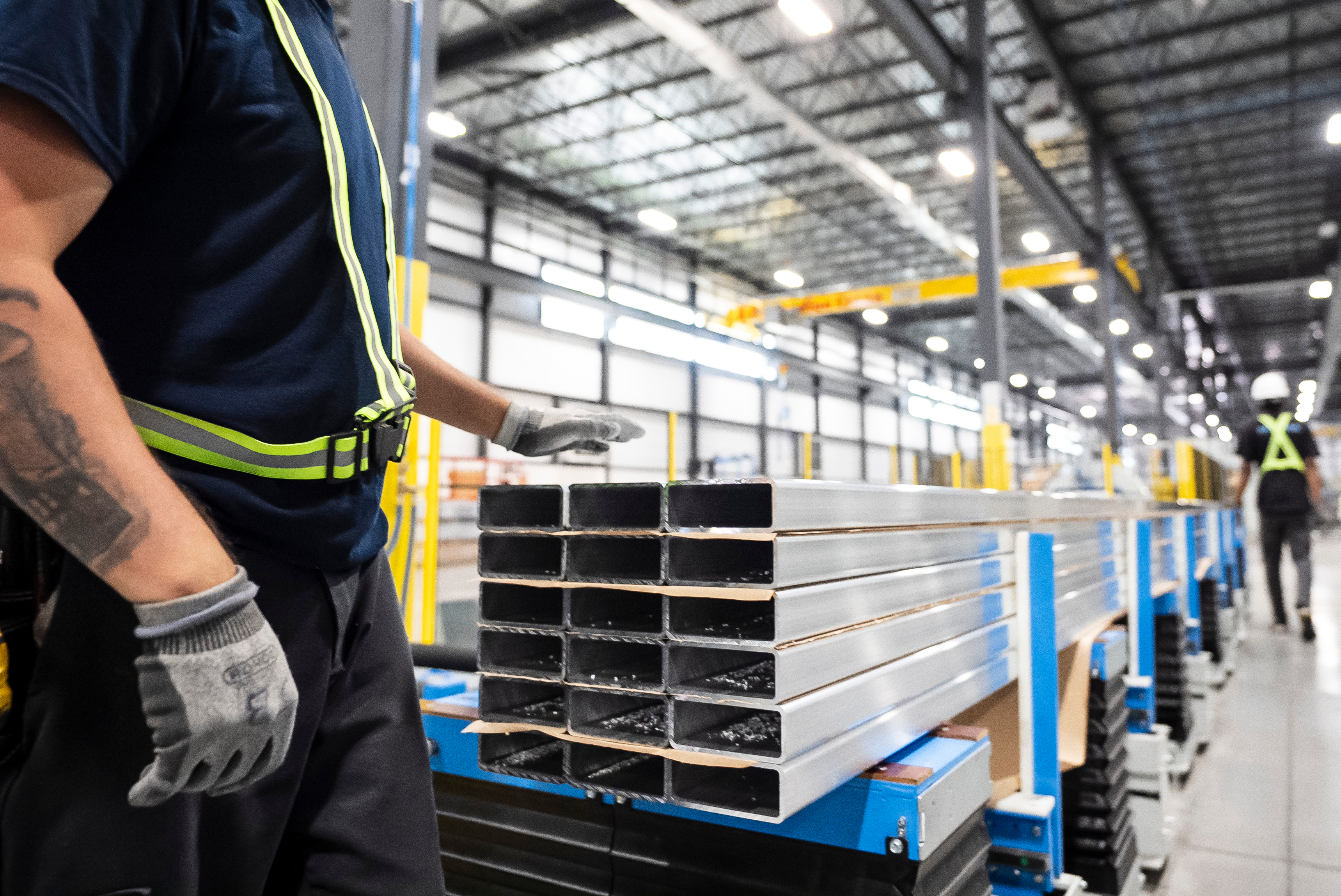 Workers prepare extruded aluminum product for packaging at Magna Aluminum Profile's fully electric powered extrusion facility in Salaberry-de-Valleyfield, Quebec, Canada, on Sept. 3, 2025.