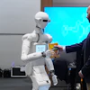A man receives a box of chocolate powder drink from a robot during a demonstration of AI-based robotics in Europe at the European Parliament in Brussels, Wednesday, Sept. 2, 2026.