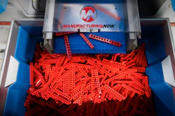 Manufacturing Now branded LEGO brick display with red plastic pieces in blue storage bin