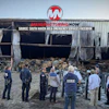 Emergency responders and firefighters assess damage at industrial warehouse with collapsed roof and debris