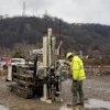 A technician pulls soil samples.