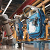 Robotic arms assembling blue car door on factory assembly line