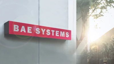 BAE Systems red and white exterior building sign mounted on modern facade with natural sunlight