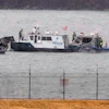 Police boat with personnel conducting water rescue operations near shoreline barrier
