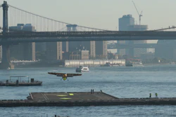 Seaplane landing on East River near Manhattan Bridge with NYC skyline in background