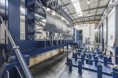 Industrial manufacturing facility with large-scale production machinery and metal framework in a warehouse setting