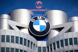 BMW logo mounted on modern building with cylindrical towers and blue sky background