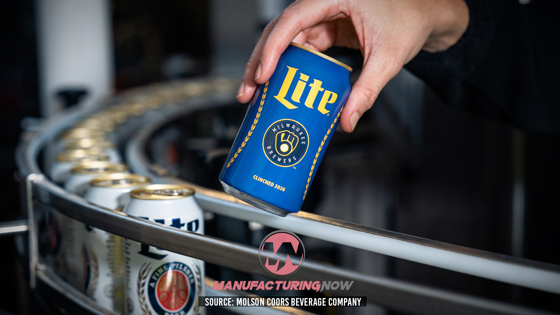 Hand holding blue Miller Lite beer can above industrial manufacturing equipment