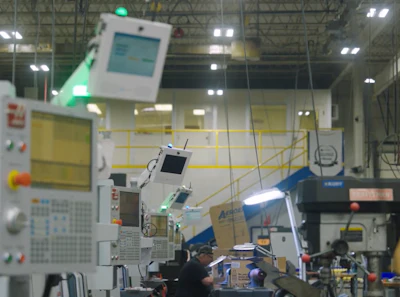 Industrial CNC manufacturing facility with automated machinery and control panels on factory floor