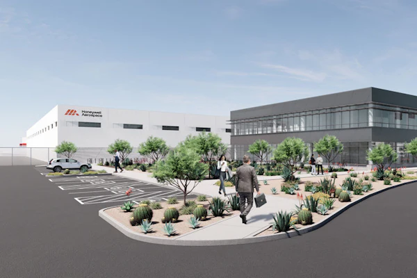Architectural rendering of modern office and industrial facility with white and gray buildings, desert landscaping, parking area, and people in courtyard.