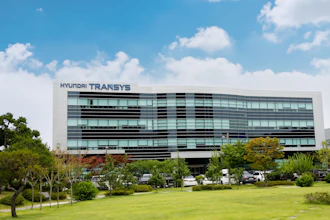 Hyundai Transys modern corporate headquarters building with glass facade and landscaped grounds under blue sky