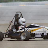 Black and white formula SAE race car with number 35 on concrete track near barrier