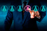 Businessman selecting a female leader icon with crown from row of employee profile icons in digital recruitment scene