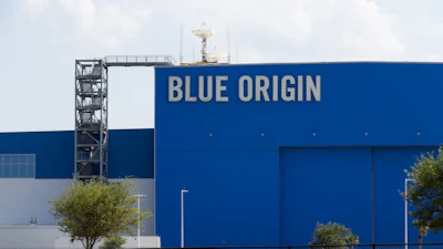 Blue Origin aerospace facility with large blue building facade displaying company name and launch tower