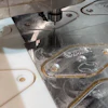 CNC machining workstation with white plastic components and metal parts with protective film during manufacturing process
