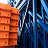 Orange and blue industrial warehouse racking system with metal shelving and structural beams
