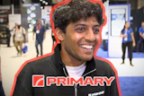 Smiling man wearing PRIMARY branded black jacket at indoor event or trade show