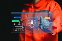 Person in orange jacket interacting with holographic cybersecurity interface displaying shield and padlock security icon