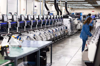 Industrial warehouse facility with rows of automated sorting machines and a worker in blue uniform monitoring operations