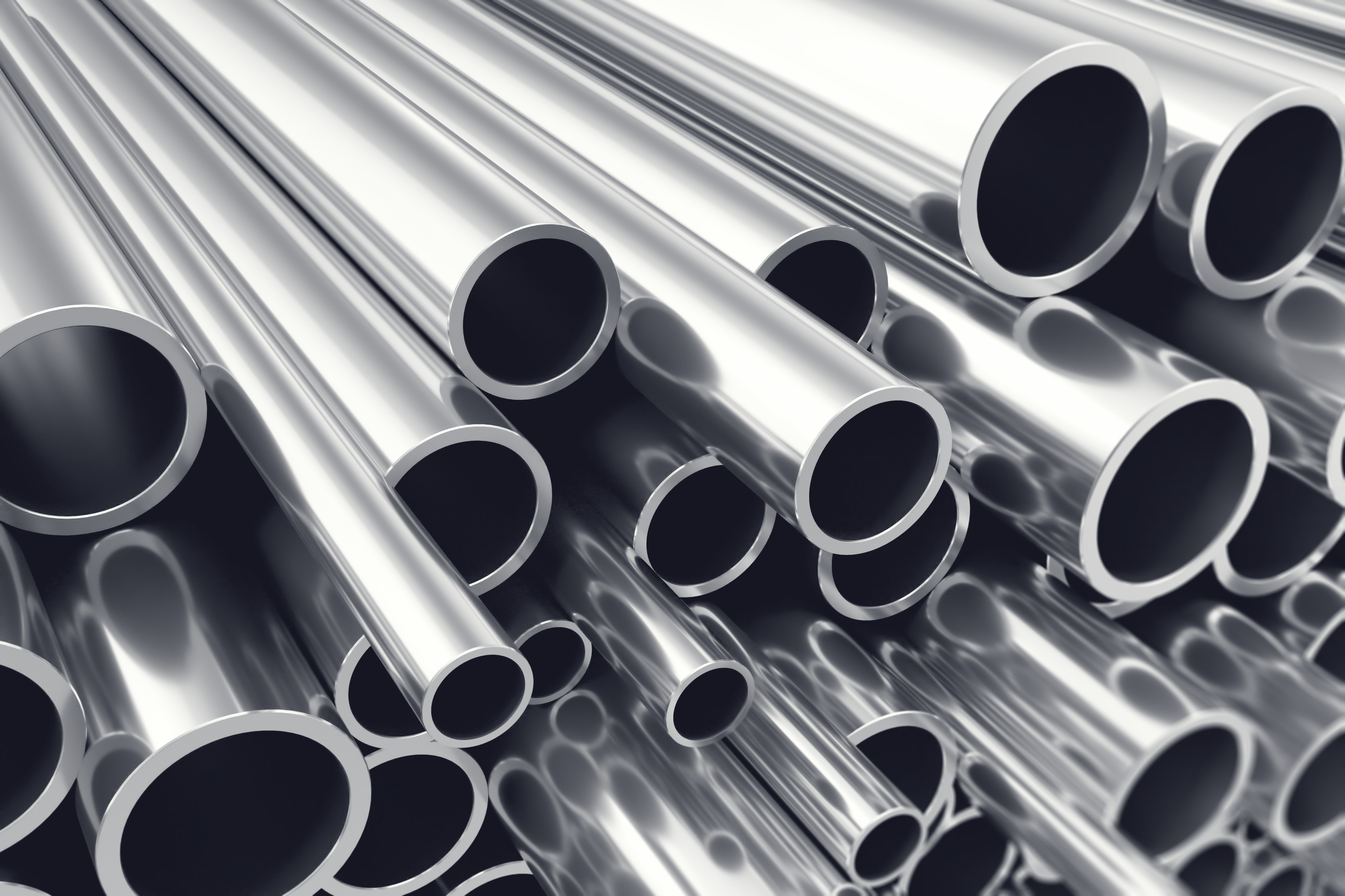 Stacked polished metal tubes and pipes arranged diagonally showing circular openings and reflective surfaces