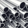 Stacked polished metal tubes and pipes arranged diagonally showing circular openings and reflective surfaces