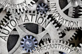Interconnected gears and cogs with overlaid business and technology keywords representing automation and industrial innovation