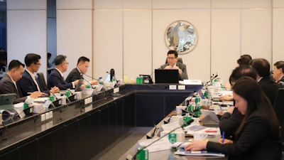 Formal business meeting with professionals seated at conference table in modern office setting