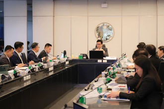 Formal business meeting with professionals seated at conference table in modern office setting