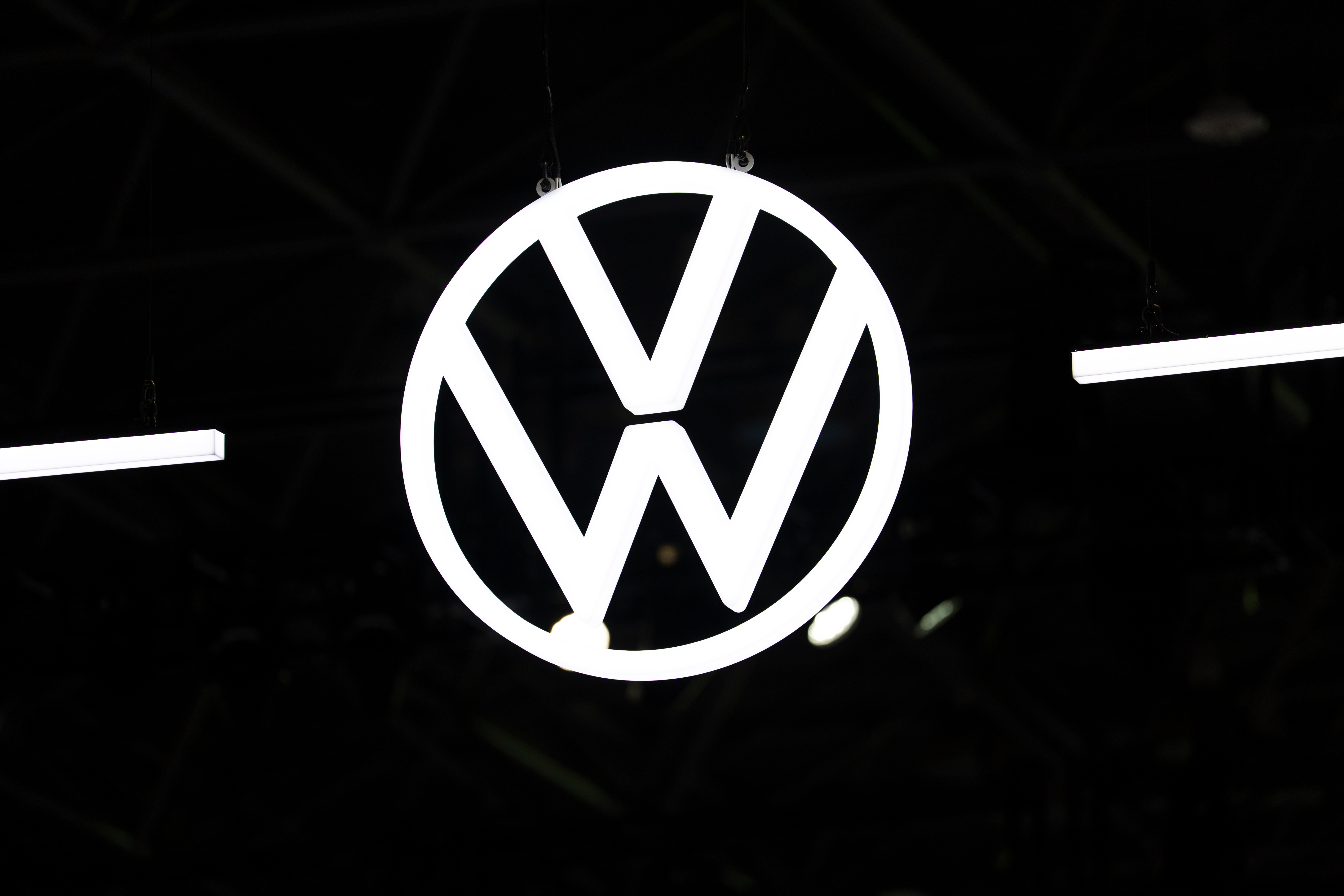 Volkswagen logo emblem illuminated against dark background