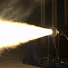Theatrical spotlight projecting bright beam of light in dark stage environment